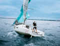 Flat in front of the sheet: The old sheet has been cast loose. It has previously been furled until the clew is in front of the forestay. Then drop further and at the same time quickly haul through the new gennaker sheet with both hands