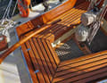 The teak thwarts, the non-slip grating and the tiller with eel head: all carved, turned, glued and sanded by ourselves.