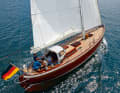 Double-ender: From the saling perspective, the pointed gate looks narrow.  Contemporary: carbon mast, rig hydraulics, push rod steering. And the moulded wood construction instead of planks