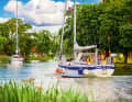 A small convoy of boats leisurely cruises along the Göta Canal. The waterway is popular with local and foreign sailors alike
