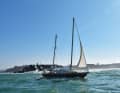 A yacht leaves the harbour of Rabat. Aft of it is a mighty stone breakwater where the Atlantic breaks with a roar during storms