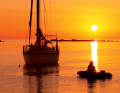 An idyllic evening at anchor. The setting sun bathes the sea in warm red tones. At night, the lights of the beacons twinkle across the sea
