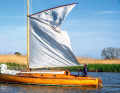 The mighty gaff mainsail is wrapped around the main boom for hoisting and reefing, the small jib is travelled on staysails