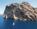 La côte rocheuse près de Formentor forme un décor spectaculaire dans lequel le bateau et l'équipage semblent être un jouet de la nature.