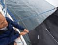 Attach the sheet: As with reefing, the windward sheet is shackled into the loose clew and led aft through the leeward tack, alternatively tack or jibe after shackling