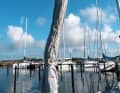 Maîtriser la voile : la housse de protection recouvrant le génois enroulé peut notamment battre bruyamment si elle n'est pas bien tendue. Cela fait vibrer tout le gréement. Outre le bruit, le tissu s'abîme considérablement. Il faut donc bien la tendre ! Il en va de même pour la housse de grand-voile. Par vent fort, on peut en outre passer une cordage autour de la bôme et de la voile déployée afin de stabiliser efficacement la voile.