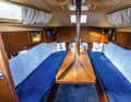 The saloon is cosy. When the table is lowered, you can sleep on a huge bed. Only the mast support remains in the way