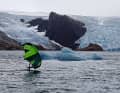 Faire du wingfoil dans un décor glacial : Un membre de l'équipage profite de ses journées dans le Prinz-Christian-Sund pour aller surfer dans un endroit très spécial.