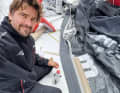 Boris Herrmann repairs a jib.  There are no spare sails on board. The total loss of a complete canvas would tear a serious hole in the finely graded wardrobe.