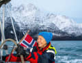 Andrea Barbera at the helm of the "Arctic Wisdom", a thermal sailing suit keeps him warm.