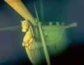 In the light of the diver’s torch, a figurehead with a fish’s tail and a horse’s head emerges from the darkness.