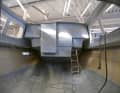 The empty hull is pushed into the hall before the boat builders start removing it.