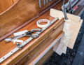Measurement: The exact shape of the hull, rubbing strake, deck and genoa rail is measured using an improvised template made from scraps of wood, cardboard and adhesive tape.