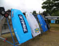 The optis are lined up in stands. They are labelled with the logos of over 100 sponsors and partners of the camp.