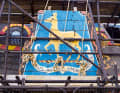 Auch die Beplankung des Heckspiegels mit dem Wappen der „Golden Hinde“ wird ersetzt. Hier ist das alte Stück auf einem Gerüst ausgestellt.