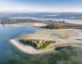 Vista aerea dell’isola dell’amore, ormai insabbiata, a sud della penisola di Mettnau, nei pressi di Radolfzell sul Lago di Costanza, durante un periodo di bassissima marea in una mattina dell’autunno del 2026, poco dopo l’alba.