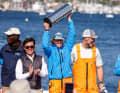 Dopo la vittoria della squadra statunitense 11th Hour Racing, Francesca Clapcich solleva il trofeo del vincitore nel cielo di Newport.