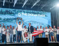 Boris Herrmann mit der Ocean-Race-Trophäe für Platz drei. Mit seinem Team auf der Bühne: kein Geringerer als Paul Cayard, der in Italien aufgrund seiner America's-Cup-Einsätze wie ein Superstar verehrt wird