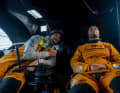 Crew mate Phillip Kasüske smiles and points to his skipper, who is taking a short rest