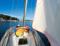 Two massive spars flank the foredeck.  The wide overlapping genoa is typical of the IOR era