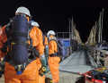 A picture that doesn't fit together: The firefighters of the hazardous materials platoon in acid protection suits on the jetty on Fehmarn