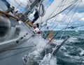 En route pour la course autour de l'île : toutes les voiles sont encore gonflées par 7 Beaufort, le "GM IV" traverse la mer avec une forte gîte.