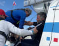 Le membre d'équipage blessé est amené sur le pont ...