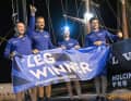 Kevin Escoffiers Team Holcim – PRB mit dem Siegerbanner für das beste Team auf Etappe 1