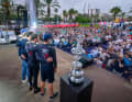 Arm in Arm feiern die Segler von American Magic ihren ersten Sieg. Den America's Cup rechts neben ihnen haben sie damit aber nicht gewonnen …