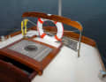 The teak-covered and mahogany-framed sliding hatch leads into the small aft cabin, which a family crew will use for the children