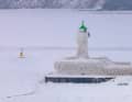 Il faro sulla punta del molo del porto di Sassnitz, sull'isola di Rügen nel Mar Baltico, è coperto da uno spesso strato di ghiaccio.
