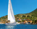 Eine Yacht segelt vor dem Ort Vathy auf der Insel Ithaka