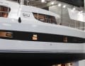 The black strip not only conceals the hull windows, but also visually flattens the height of the side walls