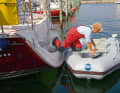The fore and aft lines hold the dinghy in position. If you don't feel confident enough to take the step, you should climb over the bank