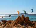 Sören, Jan and Philipp fly in formation across the bay in the evening light. The cat's professional skipper has kitesurfing experience himself and selects the next spot depending on the wind forecast and the crew's preferences. He keeps an eye on the kiting guests and can come to the rescue with the rib if necessary