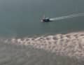Ein einsamer Kutter passiert eine Sandbank bei Langeoog