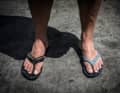 Navigator Wouter Verbraak with two different flip-flops he found on the sandbank