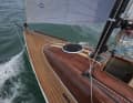 Nur optisch aus Holz. Das Deck ist mit Kunst-Teak belegt, der Kajütaufbau ist aus GFK und mit Holz überfurniert