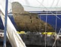 A terrible realisation. The Oyster 825 after being salvaged by crane. The keel and part of the hull are missing; there is a huge gaping hole.  On the left is the mast with the mainsail attached.
