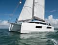 With corners and edges. The hull has pronounced chines just above the waterline. This creates volume in the hulls and narrows the waterline.