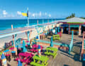 Bei einem Cocktail auf der Veranda von „Nipper’s Beach Bar“ auf Great Guana Cay schweift der Blick hinaus auf den Atlantik