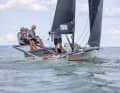 Le bateau navigue à quatre. L'équipage est assis sur les racks extensibles