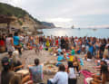Tamburi e balli al tramonto, qui sulla spiaggia di Cala Benirrás, la baia degli hippie. Gli yacht ormeggiati sullo sfondo