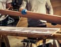Die einzelnen Lagen werden per Zahnspachtel mit angedicktem Epoxidharz bestrichen, danach wird alles mit Schraubzwingen zusammengedrückt
