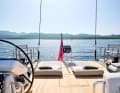 The aft deck becomes a relaxation zone. The dinghy is parked alongside underneath.