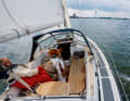 Dans le cockpit central, l'équipage est parfaitement protégé. Le chariot, placé derrière la banquette du barreur, permet de maintenir la grand-voile hors du cockpit.