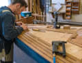 Handwerkskunst noch beinahe wie in alter Zeit: Auf einem Jollenkreuzer verlegt ein Bootsbauer ein neues Teakdeck. Eine zeitraubende Arbeit, bei der Sorgfalt gefragt ist. Leiste um Leiste wird gesägt und auf das Deck geschraubt. Danach werden die Teakfugen vergossen, bevor es ans Schleifen geht