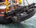 Das Heck wirkt im Vergleich zum bulligen Bug fast zierlich, allein das schwarze Beiboot, in dem Reifen und ebenfalls dunkle Fender kaum auffallen, stellt die Arbeitsbootoptik wieder her