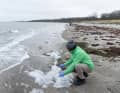 À Kühlungsborn, le Dr Julios Kontchou, de Greenpeace, prélève un échantillon de l'écume de mer pour l'analyser en vue de détecter la présence de PFAS.