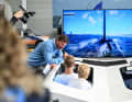 Virtuelles America’s-Cup-Training mit Profis für jedermann: Auf der Interboot darf das Publikum unter Anleitung der deutschen Cup-Youngster Lukas Hesse und Jesse Lindstädt sogar selbst ans Steuer.